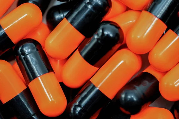 Top view of orange, black, antibiotic capsule pills — Stock Photo, Image