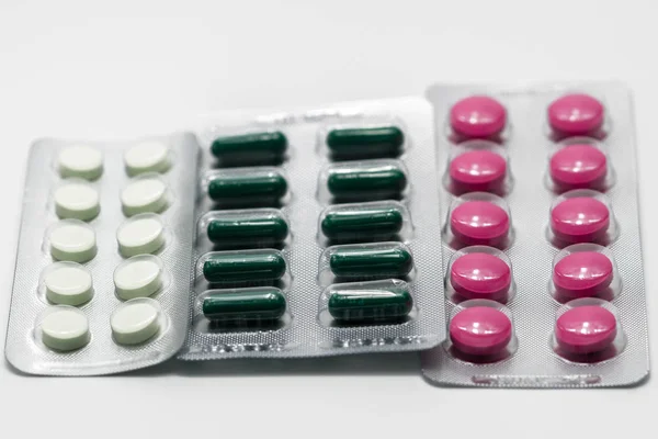 Таблетки і таблетки капсули в блістерній упаковці на білому тлі — стокове фото