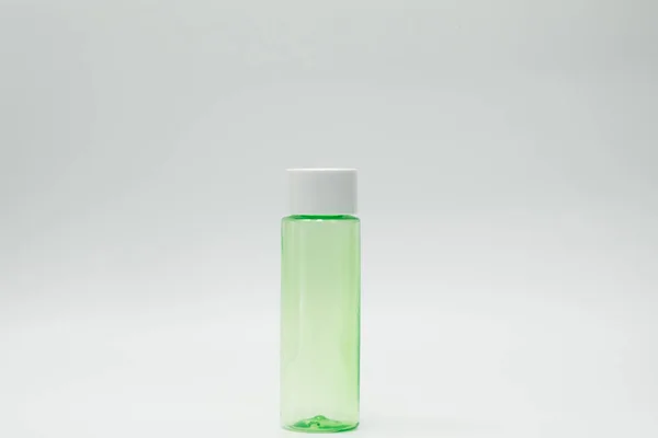 Frasco cosmético verde isolado sobre fundo branco com rótulo em branco — Fotografia de Stock