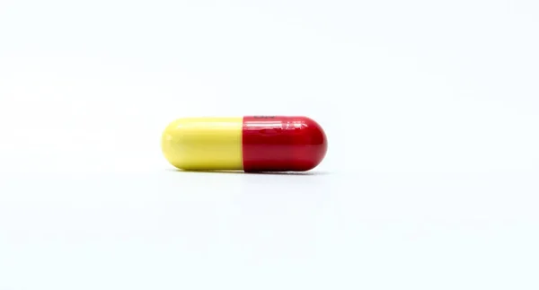 Comprimidos de cápsulas vermelhas amarelas isoladas em fundo branco com espaço de cópia — Fotografia de Stock