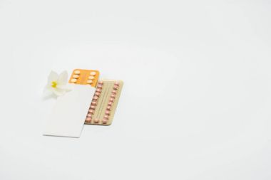 İki doğum kontrol hapları ile çiçek beyaz arka plan üzerinde paket blister. Aile planlaması kavramı