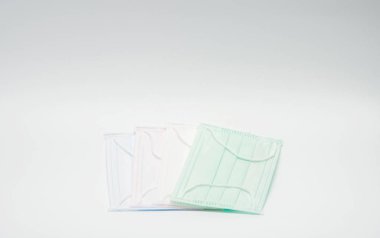 Yeşil, pembe, açık mavi ve beyaz kulak döngü tek kullanımlık yüz maskesi, ağız ve burun kapsayan için kullanılan üst üste. Vücut sıvısı ve büyük parçacıklar havada karşı korur