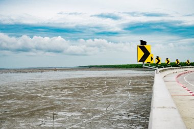 Sağa sinyal ile güneş pili temiz beton yol mangrov yüklenmeden ormanda güzel bir gökyüzü arka plan olarak, manzara vardır