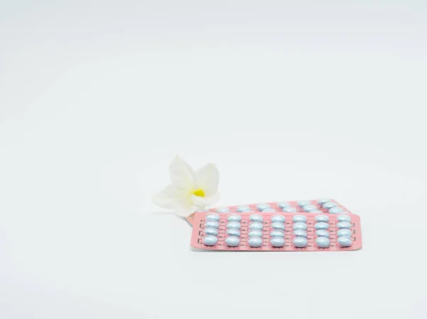 Två blister förpackning av hormoner för behandling menopausala kvinnor och blomman på vit bakgrund — Stockfoto
