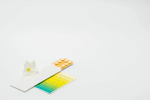Verhütungspillen mit Blume auf weißem Hintergrund. Familienplanungskonzept — Stockfoto