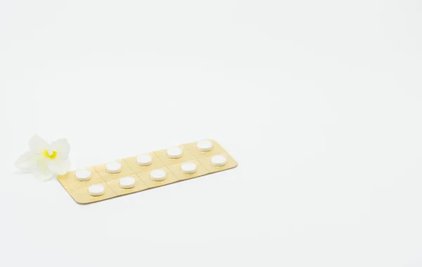 Hormoner piller för behandling menopausala kvinnor med blomma på vit bakgrund — Stockfoto