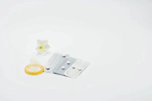 Drei-Blister-Packung mit Notfallverhütungspillen mit Kondom und Blume auf weißem Hintergrund — Stockfoto
