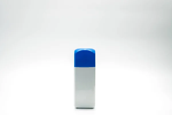 Botella de rectángulo blanco y tapa azul aislados sobre fondo blanco con etiqueta en blanco y espacio de copia — Foto de Stock