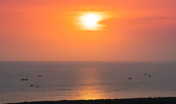 Pôr do sol bonito e reflexões sobre o mar com céu laranja têm nuvens e muitos da cabana do pescador no mar — Fotografia de Stock