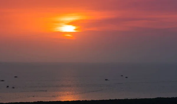 Pôr do sol bonito e reflexões sobre o mar com céu laranja têm nuvens e muitos da cabana do pescador no mar — Fotografia de Stock