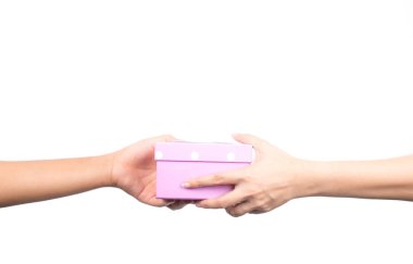Closeup hands giving and receiving pink gift box isolated on white background clipart