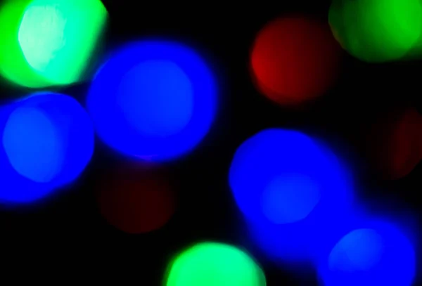 Blur luz vermelha, azul e verde no fundo escuro para o conceito de Natal com espaço de cópia — Fotografia de Stock