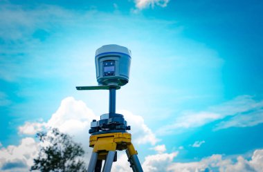 GPS surveying instrument on blue sky background clipart