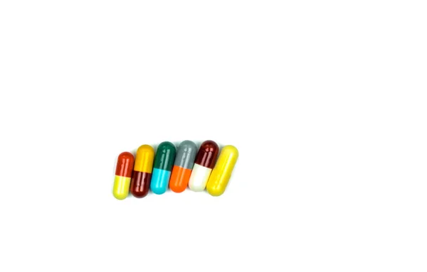 Kleurrijke van antibiotica capsules pillen in een rij geïsoleerd op een witte achtergrond met uitknippad. Resistentie tegen geneesmiddelen, gebruik van antibiotica drugs met redelijke, gezondheidsbeleid en ziektekostenverzekering concept. — Stockfoto