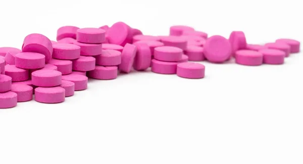 Tumpukan pil tablet merah muda yang terisolasi di latar belakang putih dengan jalur kliping. Salin ruang — Stok Foto