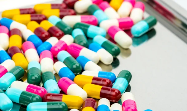Colorido de píldoras de cápsulas antibióticas con sombras en bandeja de acero inoxidable, concepto de resistencia a los medicamentos . — Foto de Stock