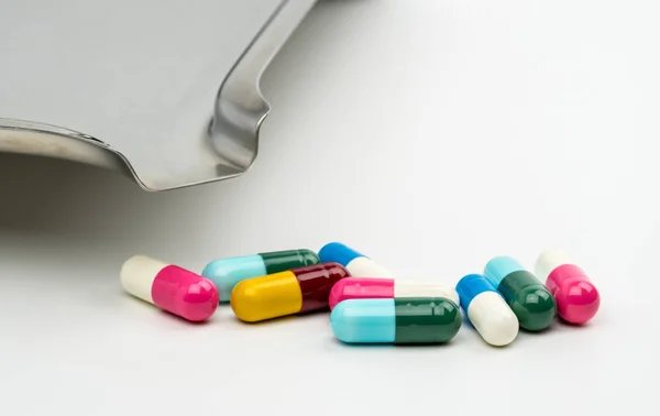 Antibiyotik kapsül hap ve paslanmaz çelik uyuşturucu tepsi kopya alanı, ilaç direnci kavramı ile beyaz arka plan üzerinde renkli. — Stok fotoğraf