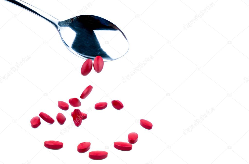 Iron tablets in spoon isolated on white background with copy space for text and clipping path. Use for topics about treatment anemia in adult, elderly people and children. Blood donations concept.