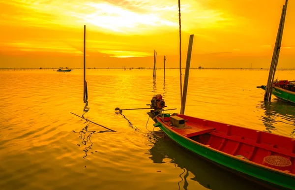 Bateau de pêcheur flottant dans la mer près du poteau de bambou au coucher du soleil en Thaïlande . — Photo