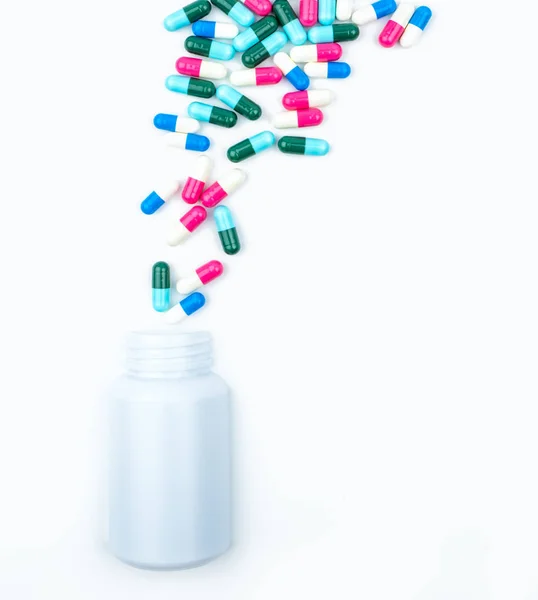 Szakadó antibiotikumok tabletták kapszula műanyag palackba, elszigetelt fehér háttér, másol hely. Kábítószer-tárolás, antibiotikum kábítószer-használat az ésszerű, egészségügyi politika és egészségbiztosítási koncepció. — Stock Fotó