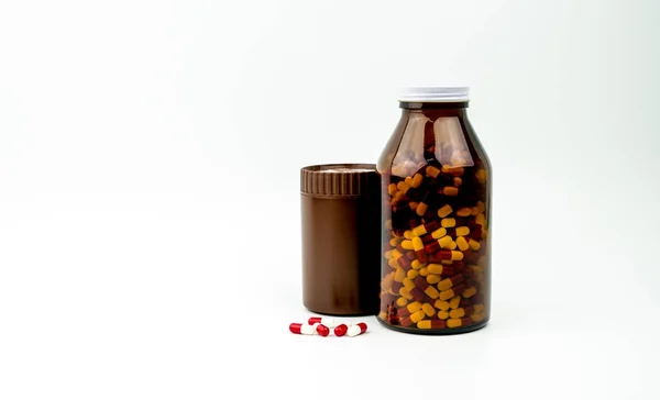 Rood, wit antibioticum capsules pillen en twee amber flessen geïsoleerd op een witte achtergrond met kopie ruimte en lege label. Resistentie tegen geneesmiddelen, antibiotica drugsgebruik met redelijke, gezondheid beleid concept. — Stockfoto