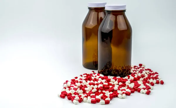 Colorido de píldoras de cápsulas antibióticas con dos botellas de vidrio ámbar aisladas sobre fondo blanco. Resistencia a los medicamentos, el uso de antibióticos con razonable, la política de salud y el concepto de seguro de salud . — Foto de Stock