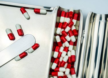 Üstten Görünüm kırmızı beyaz antibiyotik hap paslanmaz çelik uyuşturucu tepsi, ilaç direnci kavramı kapsüller. Uyuşturucu kullanımı ile makul.