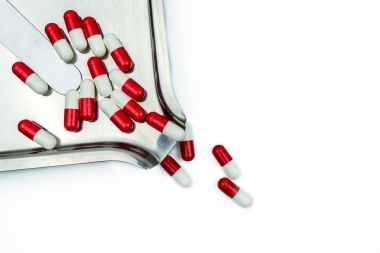 Kırmızı, beyaz antibiyotik gölge paslanmaz çelik uyuşturucu tepsisindeki haplarla kapsüller. İlaç direnci, makul ile antibiyotik ilaç kullanmak, sistem durumu ilkesi ve sağlık sigortası kavramı.