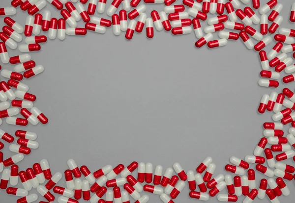 Capsules antibiotiques rouges et blanches sur fond gris avec espace de copie. Résistance aux médicaments, utilisation d'antibiotiques avec un concept raisonnable de politique de santé et d'assurance maladie . — Photo