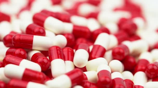 Las píldoras de cápsulas de antibióticos rojos y blancos se deslizan y se mueven de izquierda a derecha. Concepto de resistencia a medicamentos. Uso de antibióticos con un uso razonable. Salud global. Industria farmacéutica . — Vídeos de Stock