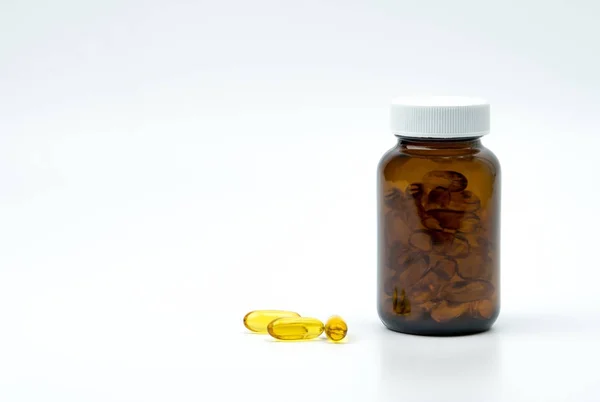 Cápsulas de aceite de pescado amarillo con frasco de vidrio ámbar con etiqueta en blanco en la mesa con espacio de copia para texto. Vitaminas y suplementos para el cuidado del corazón y la articulación. Fuente de omega 3, EPA y DHA . — Foto de Stock