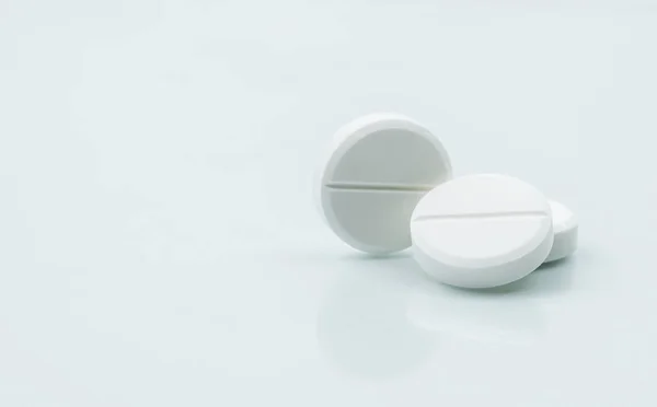 Makro snímek tři bílé žvýkací tablety na bílém pozadí se stíny. Antacida pilulky pro úlevu bolesti žaludku od přebytečné žaludeční kyseliny v žaludku. Stres vyvolat žaludeční vřed ošetřovatelský koncept. — Stock fotografie