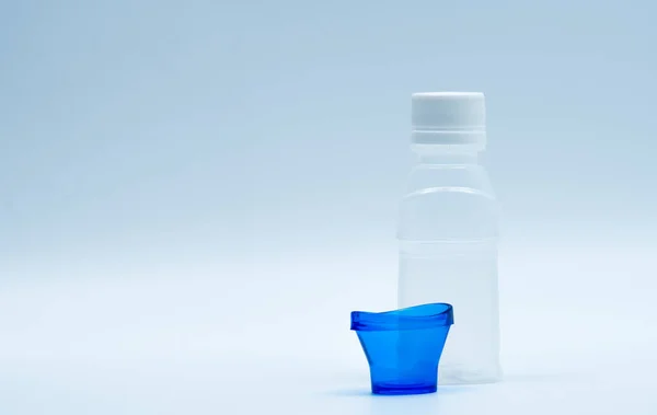 Steriele oog lotion in witte plastic fles met blauwe eyebath en kopie ruimte en lege label. Ogen wassen na contact verontreiniging milieu of na het zwemmen in chloor besmetten zwembad. — Stockfoto