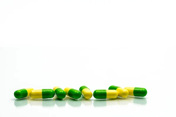 Green, yellow tramadol capsule pills on white background with shadows and copy space. Cancer pain management. Opioid analgesics. Drug abuse in teenage in Thailand. — Stock Photo, Image