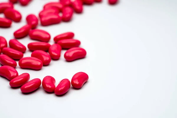 Selektiver Fokus der roten Nierenform zuckerbeschichtete Tabletten auf weißem Hintergrund mit Kopierraum — Stockfoto