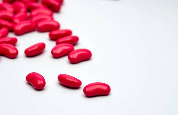 Comprimidos de comprimidos revestidos de açúcar de forma renal vermelha isolados em fundo branco com espaço de cópia para texto . — Fotografia de Stock