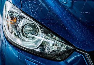 Mavi kompakt Suv araç spor ve modern tasarımı ile su ile yıkama. Araç Bakım Servisi iş kavramı. Yüksek basınçlı su spreyi ile temizlendikten sonra araba su damlaları ile kaplı