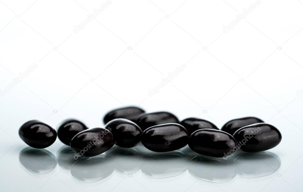 Black tablet pills on a white background. Vitamins and minerals tablets for pregnant women. Ferrous fumarate anemia treatment tablets pills.