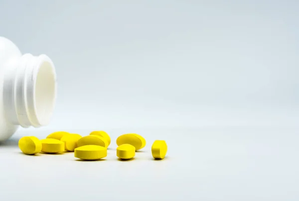 Pillole ovali gialle e bottiglia bianca aperta su sfondo bianco con bellissimo motivo creativo e spazio per copiare il testo. Gestione del dolore da lieve a moderata. Antidolorifici . — Foto Stock