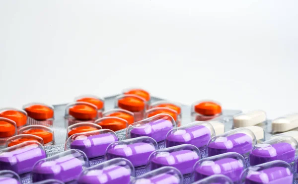 Macro schoot detail van Oranje, paarse en witte tabletten pillen in blisterverpakking op witte achtergrond. Kleurrijke geneeskunde voor pijn verlichten. NSAID's drug voor anti-ontsteking kan veroorzaken maagzweer. — Stockfoto