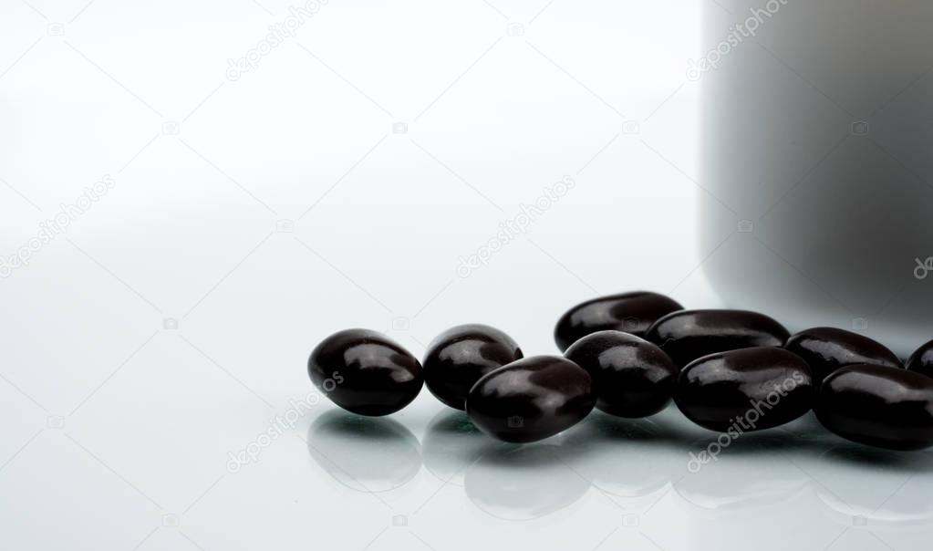 Black tablet pills on a white background. Vitamins and minerals tablets for pregnant women. Ferrous fumarate anemia treatment tablets pills.
