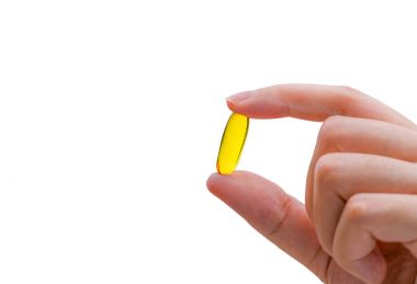 Genç kadın elini tut balık yağı kapsül. Omega-3 hapları kadın. Kavramı, vitaminler ve Takviyeler.