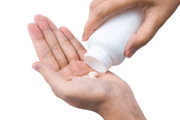 Mujer adulta mano verter pastillas de plástico blanco frasco en su mano aislado sobre fondo blanco. Atención sanitaria en personas adultas — Foto de Stock