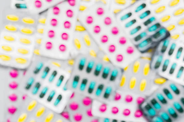 Sfondo sfocato di mucchio colorato di pillole in blister. Uso di droghe con un concetto ragionevole. Carta da parati sanitaria globale . — Foto Stock