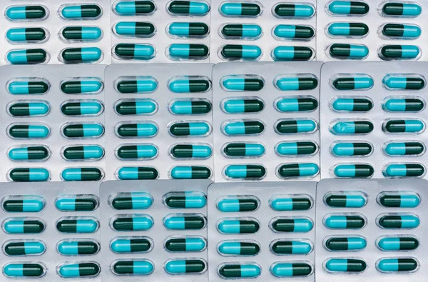 Cuadro completo de píldoras de cápsulas de antibióticos azules y verdes en blisters. Resistencia a los medicamentos antimicrobianos y uso de antibióticos con un concepto razonable. Fondo de la droga de la amoxicilina (penicilina) . — Foto de Stock