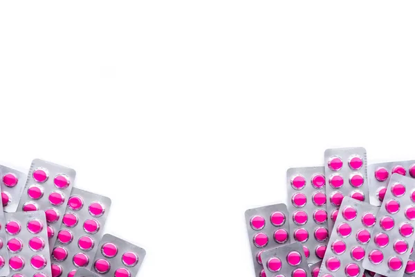 Круглые розовые таблетки таблетки в блистерных пакетах на белом фоне с копировальным пространством. таблетки для облегчения боли, высокой температуры, головной боли, зубной боли и воспаления ран — стоковое фото