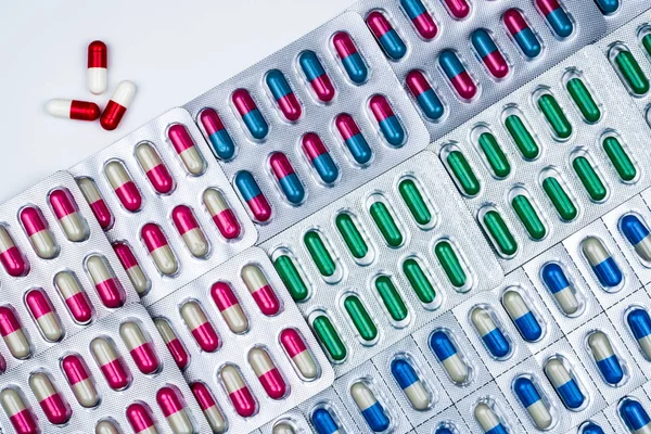 Vista dall'alto di capsule colorate in blister disposte con un bellissimo modello. Imballaggio farmaceutico. Medicina per le infezioni malattia. Uso di antibiotici con ragionevole. Resistenza al farmaco . — Foto Stock