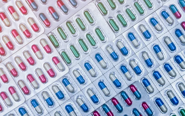Cornice completa di capsule colorate in blister disposte con un bellissimo modello. Imballaggio farmaceutico. Medicina per le infezioni malattia. Uso di antibiotici con ragionevole. Resistenza al farmaco . — Foto Stock