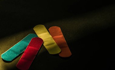 Giyinme İlkyardım (sıva) ile non-sopa yastık için çabuk kopya alanı ile koyu arka plan üzerinde yaranın normal iyileşmesi. Steril yara pansuman parlak renk ile imalat sanayi gıda tespit etmek kolaydır