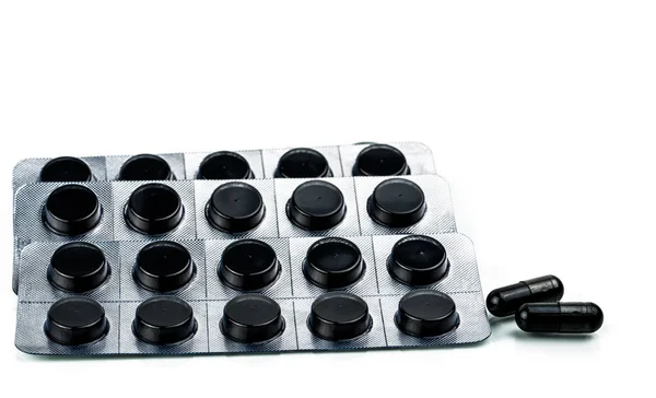 Kapsler og tabletter av aktivt kull i blisterpakning isolert på hvit bakgrunn – stockfoto